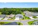 Aerial shot of a neighborhood showcasing well-maintained homes, lush greenery, and mature trees in a peaceful setting at 6988 Lawrenceville Way, The Villages, FL 34762