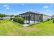 Well-manicured backyard featuring a screened lanai with a pool and landscaped garden at 6988 Lawrenceville Way, The Villages, FL 34762