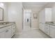 Bright bathroom boasts double vanity with granite countertop and cabinet storage at 6988 Lawrenceville Way, The Villages, FL 34762