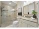 An ensuite bathroom with a glass shower, granite countertop, and tile floors at 6988 Lawrenceville Way, The Villages, FL 34762