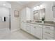 Well-lit bathroom featuring double vanity with granite countertop and storage cabinet at 6988 Lawrenceville Way, The Villages, FL 34762