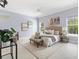 Primary bedroom with neutral tones, ceiling fan, and many windows at 6988 Lawrenceville Way, The Villages, FL 34762