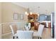 Dining area with glass table, seating for four, and view into kitchen at 6988 Lawrenceville Way, The Villages, FL 34762