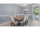 A formal dining room with crown molding, neutral colors, and large glass doors to the outside pool at 6988 Lawrenceville Way, The Villages, FL 34762