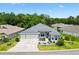 Beautiful single-story home featuring a three-car garage and meticulously manicured landscaping at 6988 Lawrenceville Way, The Villages, FL 34762