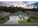 Beautiful single-story home with a well-manicured lawn, mature trees, and a three-car garage at 6988 Lawrenceville Way, The Villages, FL 34762