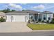 Lovely single-story home with a three-car garage, manicured lawn, and an inviting entrance at 6988 Lawrenceville Way, The Villages, FL 34762