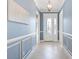Elegant entryway with blue walls, white trim, chandelier, and decorative glass front door at 6988 Lawrenceville Way, The Villages, FL 34762