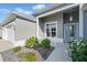 Cozy front porch featuring a manicured garden, stylish lighting, and an inviting entrance at 6988 Lawrenceville Way, The Villages, FL 34762