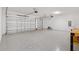 Spacious two-car garage featuring an epoxy floor and white walls, perfect for storage and vehicle parking at 6988 Lawrenceville Way, The Villages, FL 34762