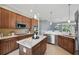 A kitchen with stainless steel appliances, a kitchen island, and open to the dining room at 6988 Lawrenceville Way, The Villages, FL 34762