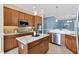 Open kitchen boasts an island, stainless steel appliances, and ample cabinetry at 6988 Lawrenceville Way, The Villages, FL 34762