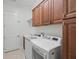 A laundry room with a washer, dryer, sink, and cabinetry for storage at 6988 Lawrenceville Way, The Villages, FL 34762