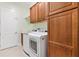 Functional laundry room equipped with a washer, dryer, storage cabinets and a utility sink, offering convenience at 6988 Lawrenceville Way, The Villages, FL 34762