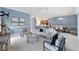 Open living room features bright neutral colors, and view into kitchen and dining area at 6988 Lawrenceville Way, The Villages, FL 34762