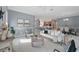 Open-concept living room showcasing stylish furnishings, neutral colors, and seamless flow to the kitchen at 6988 Lawrenceville Way, The Villages, FL 34762