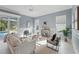 Bright living room boasts modern decor, tile floors, and sliding door access to the pool area at 6988 Lawrenceville Way, The Villages, FL 34762
