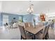 Open concept living room with dining area, kitchen, and view of backyard at 6988 Lawrenceville Way, The Villages, FL 34762