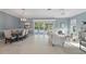 Spacious living and dining area with neutral tones, tile flooring, and pool views through sliding glass doors at 6988 Lawrenceville Way, The Villages, FL 34762
