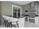 Stylish outdoor kitchen features a grill, bar seating, and stainless steel appliances at 6988 Lawrenceville Way, The Villages, FL 34762