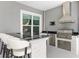 Outdoor kitchen with a stone bar, stainless steel grill, and built-in appliances at 6988 Lawrenceville Way, The Villages, FL 34762
