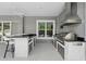Modern outdoor kitchen features a grill, stainless steel appliances, and a bar at 6988 Lawrenceville Way, The Villages, FL 34762