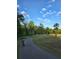 Scenic bike path winding through a lush park, complete with mature trees and a tranquil lakeside view at 6988 Lawrenceville Way, The Villages, FL 34762