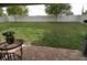 View of the backyard with lush green grass, privacy fence, and brick paver patio at 709 Calabria Way, Howey In The Hills, FL 34737