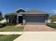 Charming single-story home featuring a brick driveway and lush landscaping at 709 Calabria Way, Howey In The Hills, FL 34737