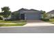 Inviting single-Gathering home with a well-maintained lawn, brick driveway, and a two-car garage at 709 Calabria Way, Howey In The Hills, FL 34737