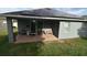 View of the rear patio, featuring brick pavers, seating, and solar panels on the roof at 709 Calabria Way, Howey In The Hills, FL 34737