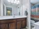 Updated bathroom boasts dark wood cabinetry, double vanity, and a stylish shower curtain at 718 Lake Douglas Dr, Groveland, FL 34736