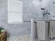 Modern bathroom with a glass-enclosed shower, gray tile, and mosaic floor at 718 Lake Douglas Dr, Groveland, FL 34736