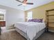 Cozy bedroom features a large bed with a colorful comforter, a ceiling fan, and natural light at 718 Lake Douglas Dr, Groveland, FL 34736