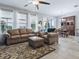 Bright living room with a leather sofa set, patterned rug, and view of the adjacent dining area at 718 Lake Douglas Dr, Groveland, FL 34736