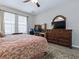 Well-lit main bedroom with a king-size bed, wood flooring, and an office area at 718 Lake Douglas Dr, Groveland, FL 34736