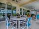 Covered outdoor patio with ceiling fan, white table and chairs and seating area at 718 Lake Douglas Dr, Groveland, FL 34736