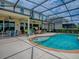 Inviting screened-in pool with easy access steps, surrounded by a spacious patio and covered seating at 718 Lake Douglas Dr, Groveland, FL 34736