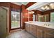 Bathroom with double vanity, framed mirrors, walk in shower, and garden view at 7249 Chesterhill Cir, Mount Dora, FL 32757