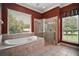 Bathroom featuring tub, glass shower, and large window at 7249 Chesterhill Cir, Mount Dora, FL 32757