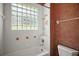 Bathroom with neutral finishes, a glass block window, and a tub/shower combo at 7249 Chesterhill Cir, Mount Dora, FL 32757