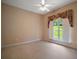Bright bedroom featuring neutral walls, large window with floral curtains, and a ceiling fan at 7249 Chesterhill Cir, Mount Dora, FL 32757