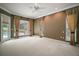 Bedroom featuring large windows, neutral carpet, and decorative curtains at 7249 Chesterhill Cir, Mount Dora, FL 32757