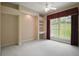 Bedroom featuring built-in shelves, neutral carpet, and a large window at 7249 Chesterhill Cir, Mount Dora, FL 32757