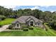 Charming home features a landscaped front yard, mature trees, and stylish architectural details at 7249 Chesterhill Cir, Mount Dora, FL 32757
