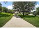 A long driveway leads to a home with mature trees that dot the large manicured yard at 7249 Chesterhill Cir, Mount Dora, FL 32757