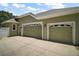 Side view of a large garage with plenty of parking space and a door that leads to the side yard at 7249 Chesterhill Cir, Mount Dora, FL 32757