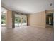 Open living room features tile flooring, large windows, and sliding glass doors to the backyard at 7249 Chesterhill Cir, Mount Dora, FL 32757