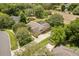 Aerial view showcasing a spacious home with lush landscaping and a well-manicured lawn at 7685 Lake Angelina Dr, Mount Dora, FL 32757