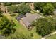 A high angle view of a home with a screened pool and well maintained surrounding landscape at 7685 Lake Angelina Dr, Mount Dora, FL 32757